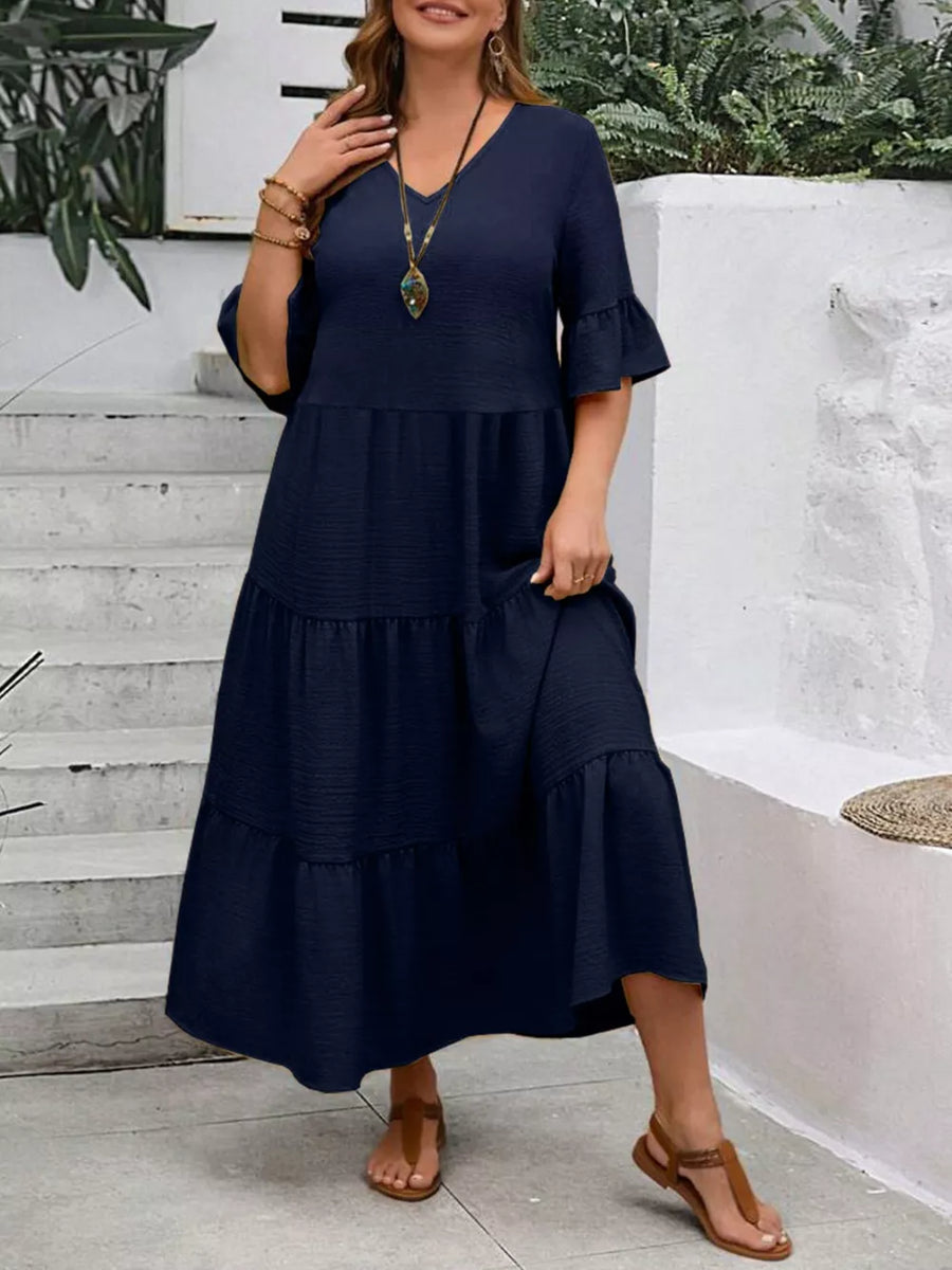 Navy blue tiered midi dress with ruffle sleeves and V-neck.