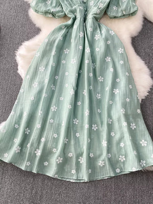 Light green embroidered puff sleeve midi dress with white floral pattern and button detail.