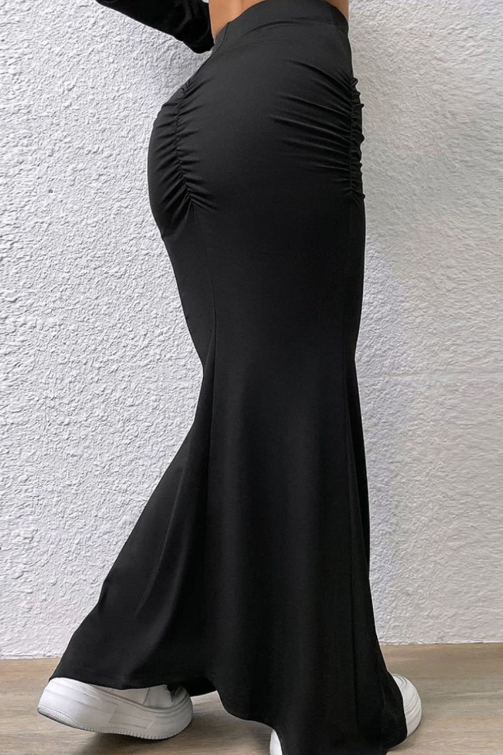 Black ruched waistline fishtail maxi skirt with a flared hem.