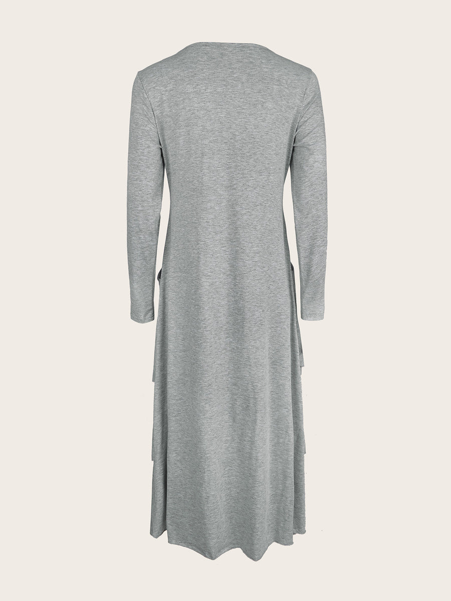 Light gray long sleeve midi dress with asymmetrical tiered hem and pockets.