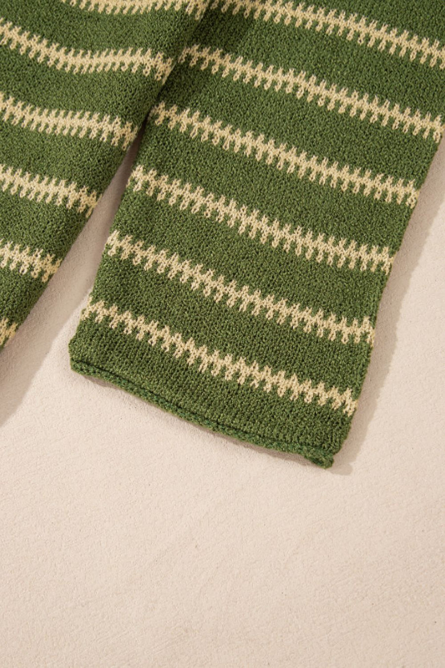 Moss green knit sweater with textured cream stripes and a relaxed fit.