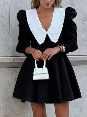 Black mini dress with puff sleeves and a white ruffled collar, A-line skirt.