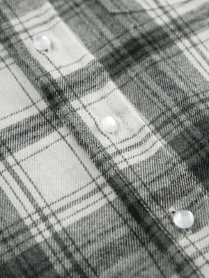 Button-up long sleeve shirt in black and white plaid cotton with pearl buttons.