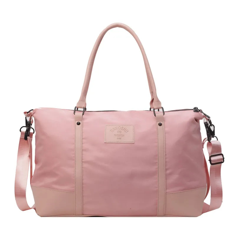 Blush pink duffel bag with leather accents and adjustable strap for travel or gym.