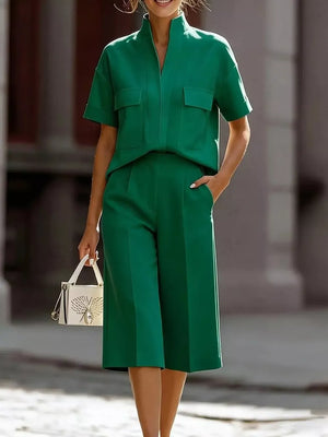Green two-piece set with short sleeves, collared neckline, and pocketed top, paired with wide-leg culottes.