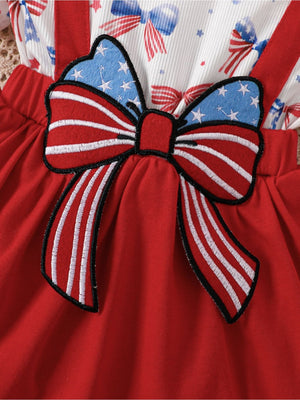 Red cotton baby dress with patriotic bow detail and star print straps.