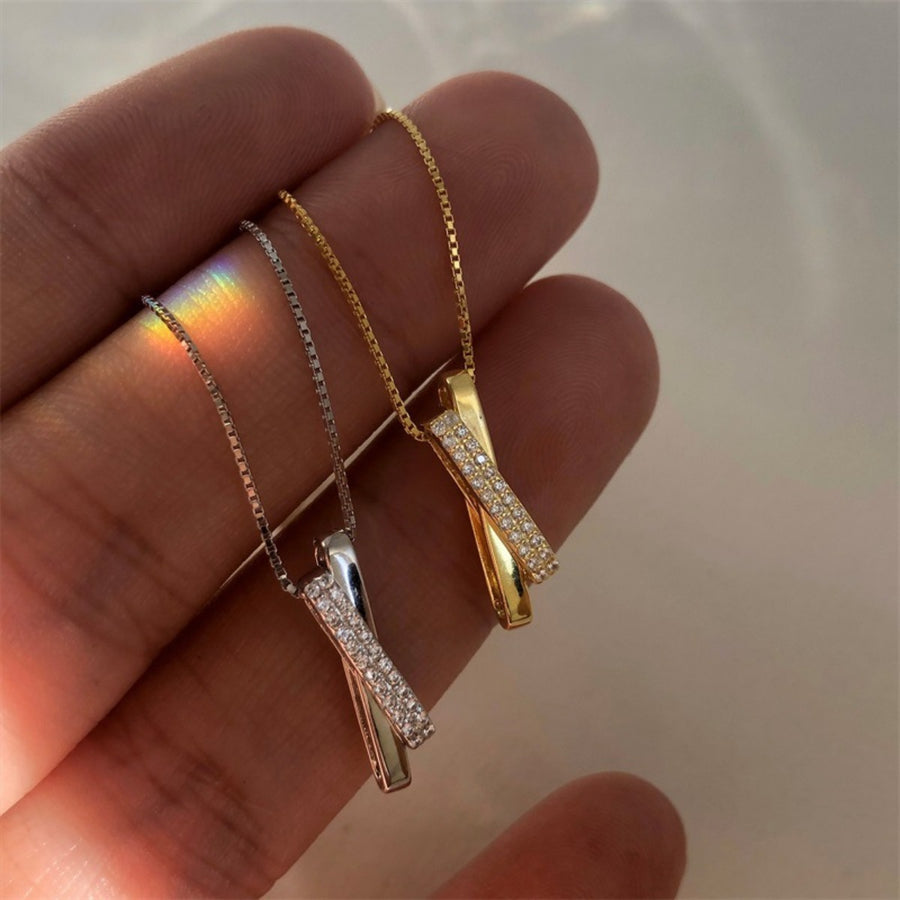 Sterling silver and gold crossover pendant necklaces with pave zircon details on box chains.
