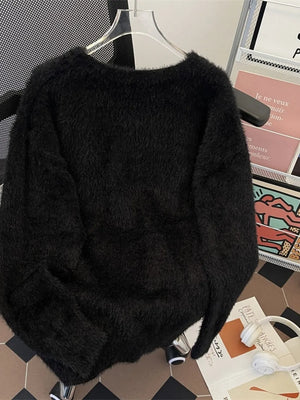 Black oversized fuzzy knit sweater with crewneck and long sleeves.
