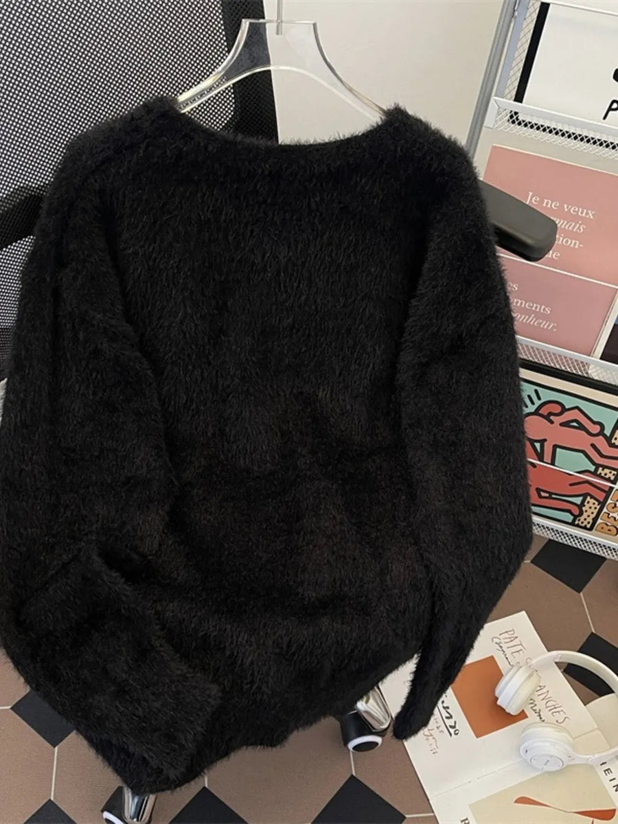 Black oversized fuzzy knit sweater with crewneck and long sleeves.