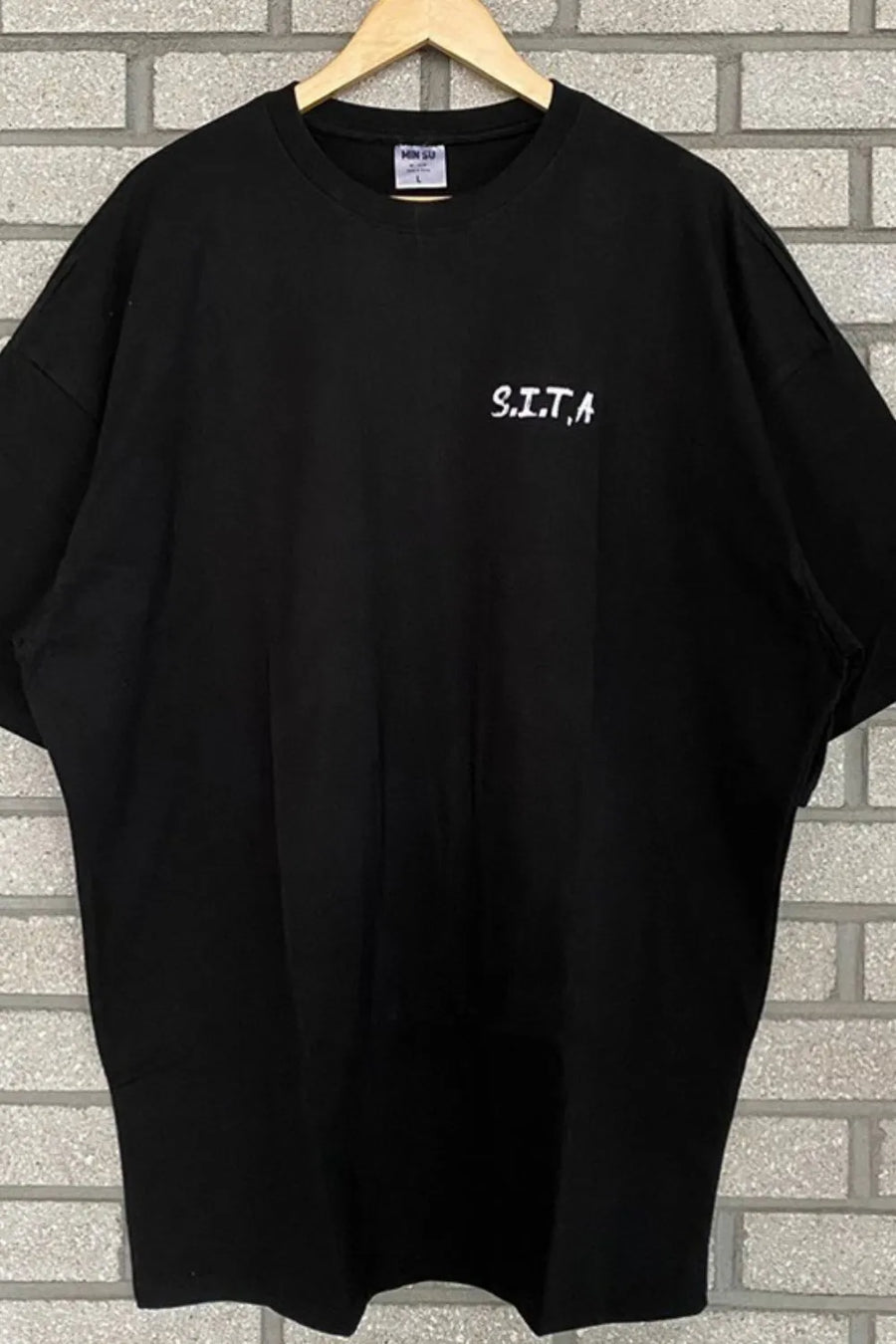Black oversized t-shirt with white S.I.T.A. text graphic on chest