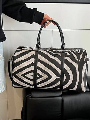 Large black and white zebra print duffle bag with carry handles and a detachable strap.