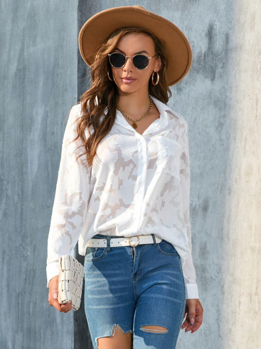White sheer floral embroidered button-down blouse with long sleeves and collar.