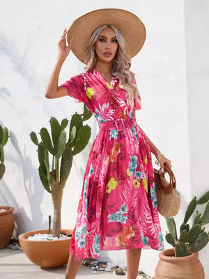 Hot pink tropical pleated midi dress with belt and short sleeves.