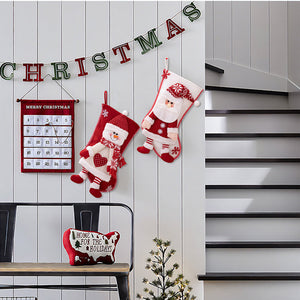 Plush Santa and Snowman Christmas stockings with festive details, hanging on a wall.
