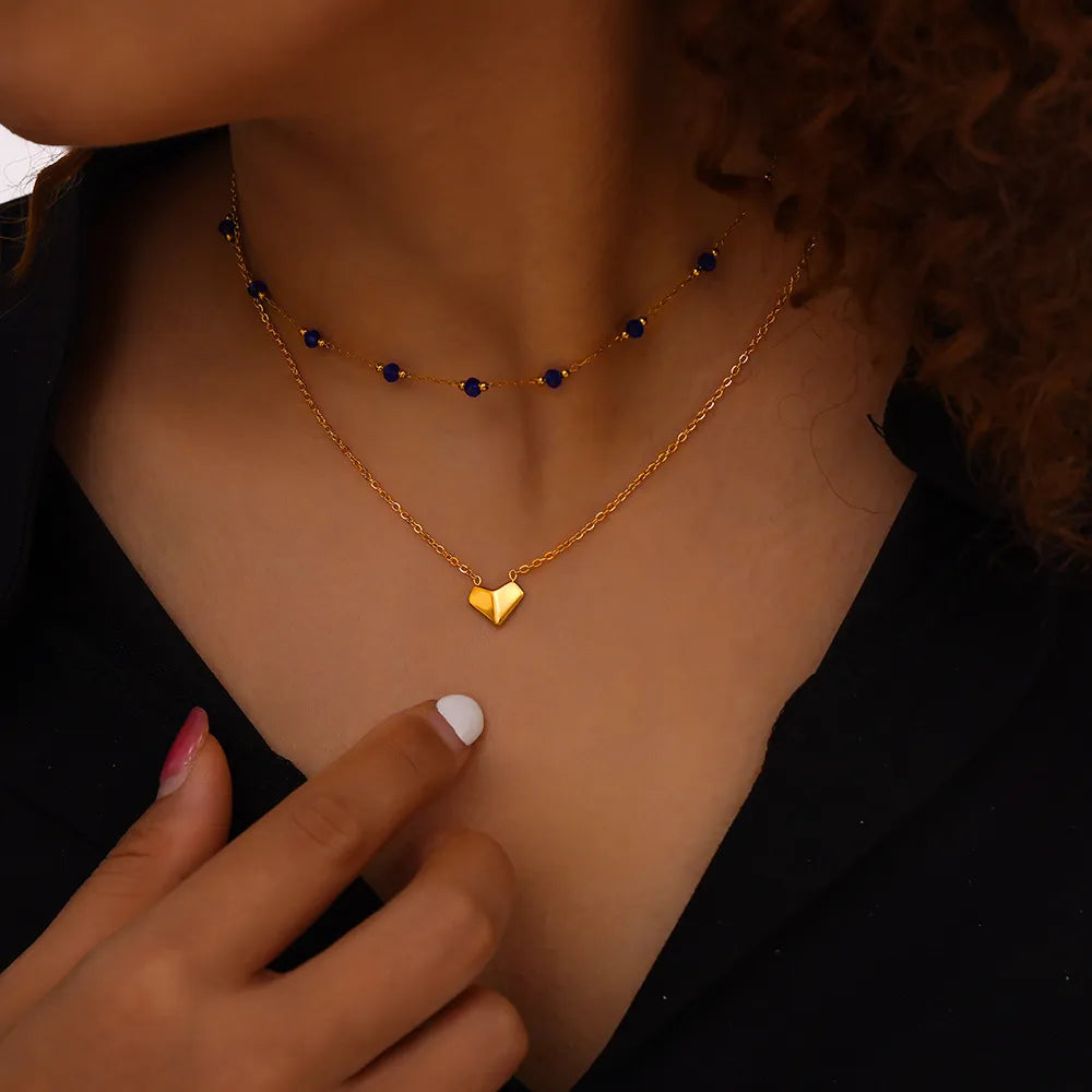 Gold layered necklace with blue beads and a heart pendant