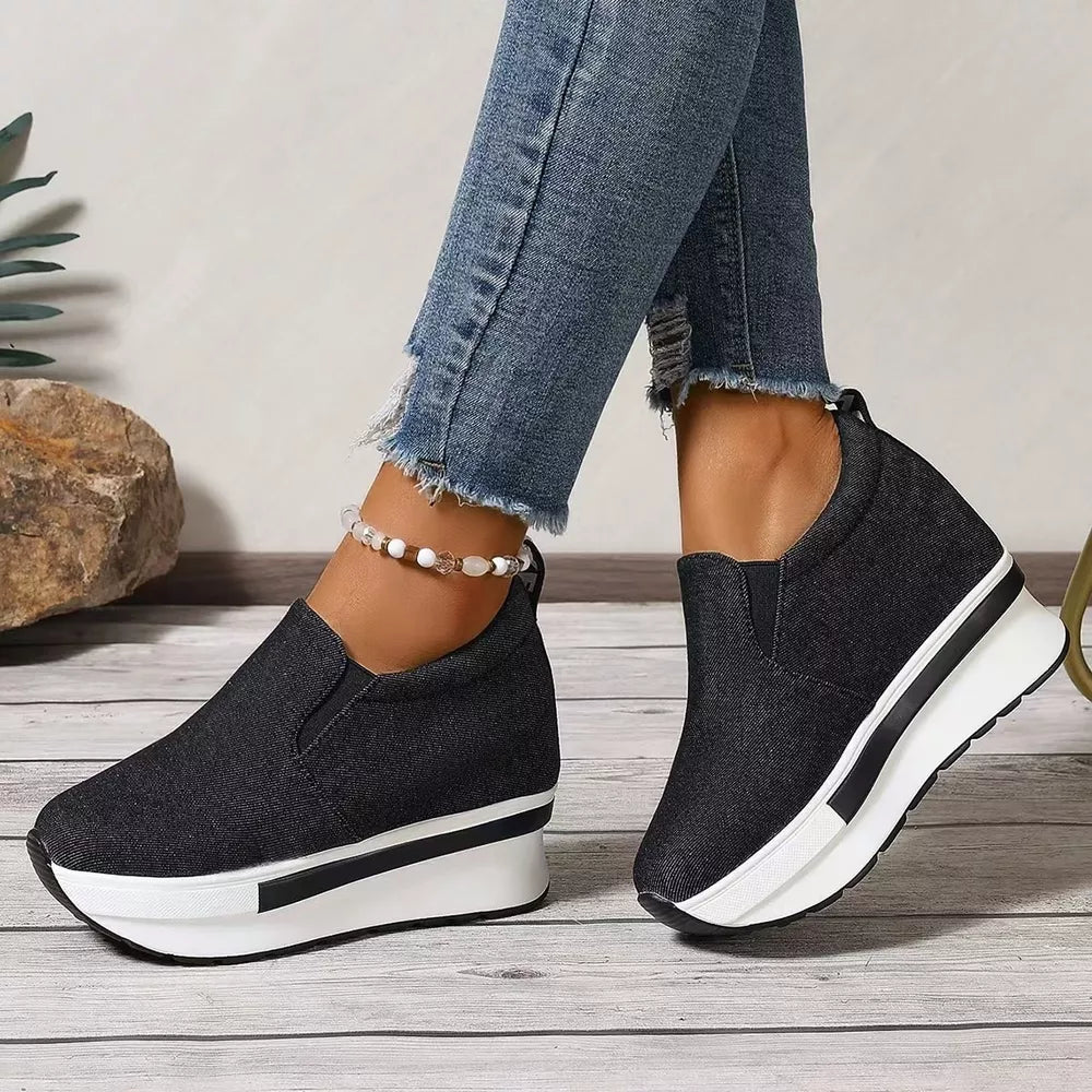 Black round-toe slip-on platform shoes with chunky white soles and black trim.