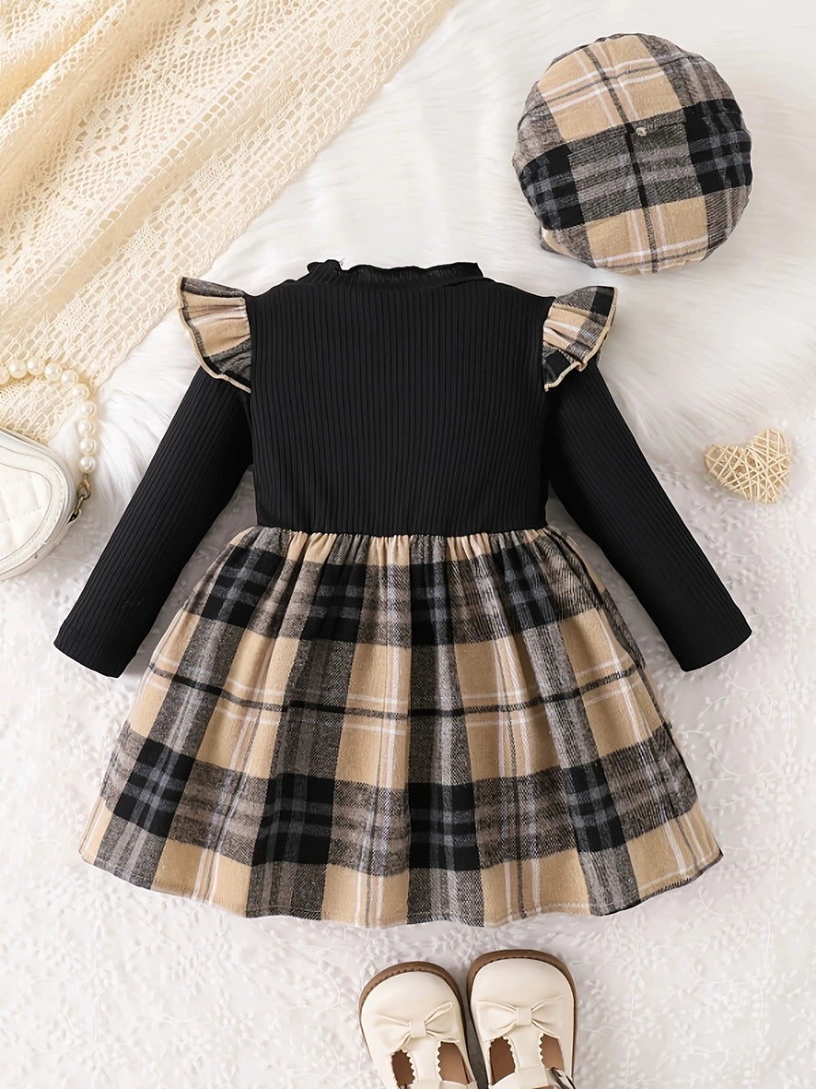 Baby girls' black ribbed dress with plaid skirt and ruffled sleeves, includes matching hat.