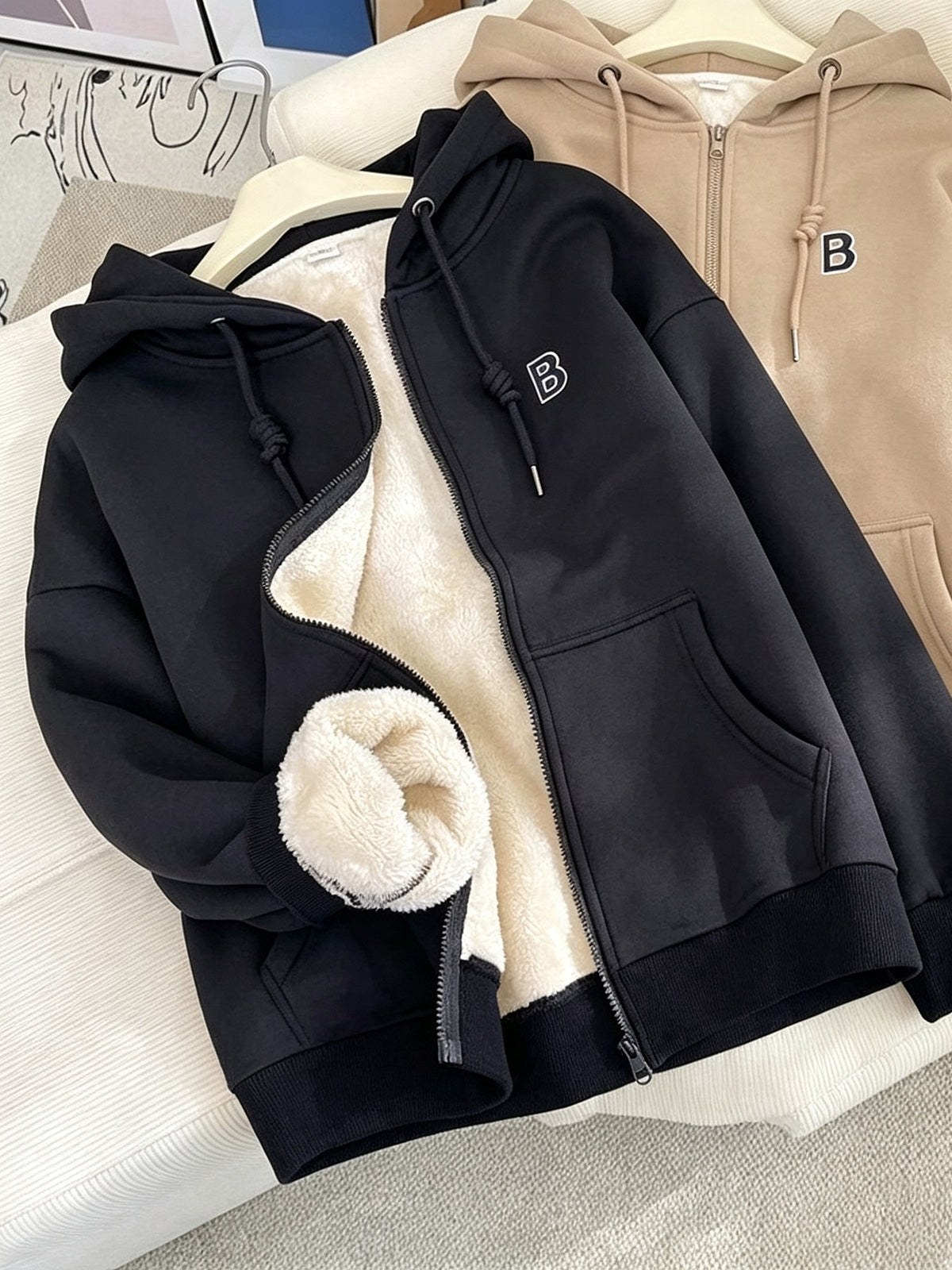 zip hoodie in black featuring drawstring and relaxed fit