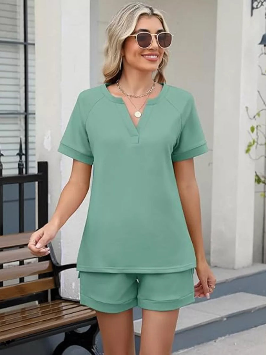 Green relaxed two-piece set with v-neck top and shorts, featuring pockets.