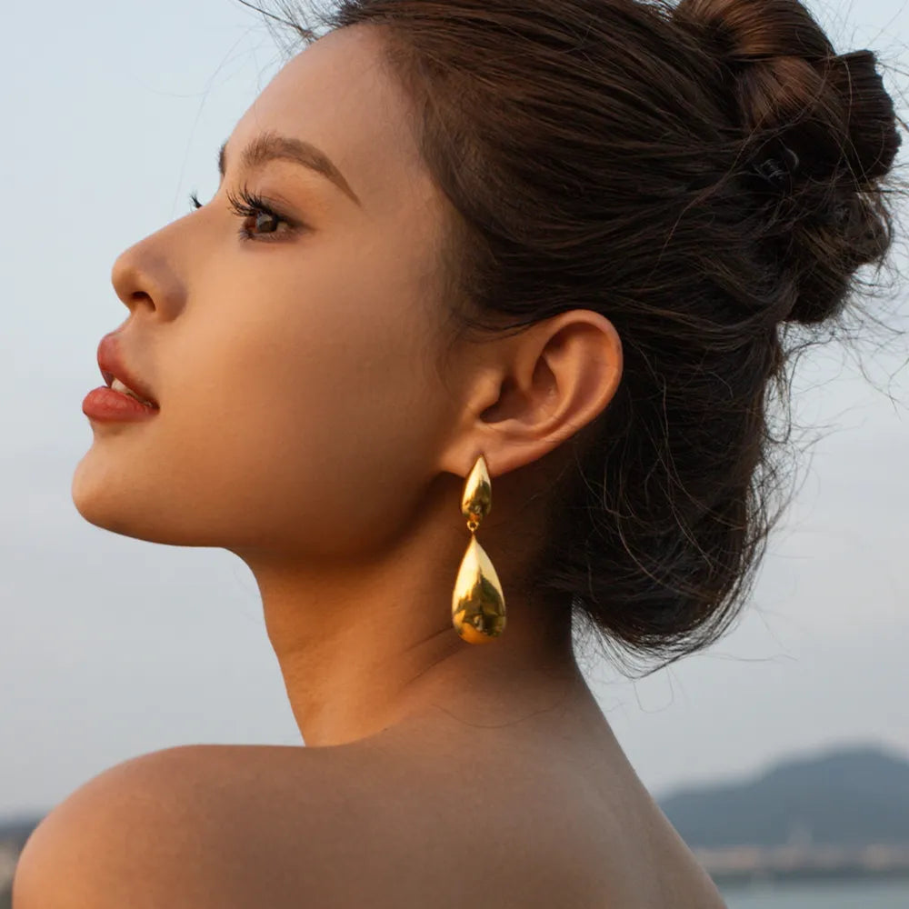 Gold teardrop dangle earrings with a high-shine finish.