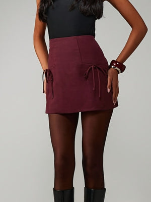 Burgundy high-waisted mini skirt with tie-side pockets and a comfortable fit.