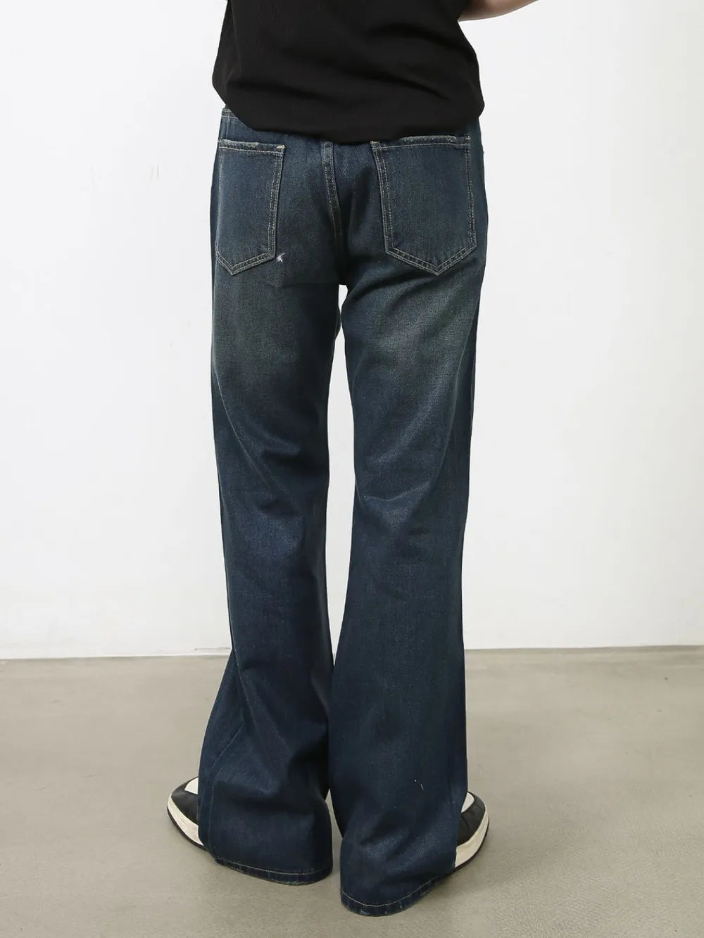 Flared dark wash denim jeans with subtle fading and bootcut leg