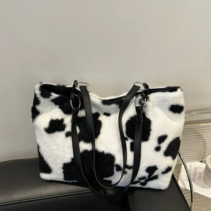 Cowhide print faux fur shopper bag with black faux leather straps and silver hardware.