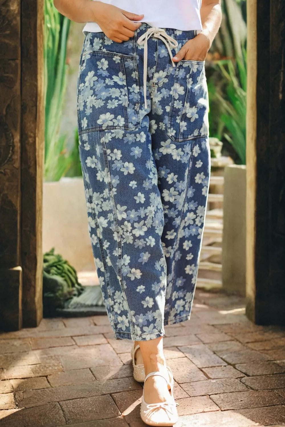 Floral barrel jeans in blue denim with drawstring waist and pockets.