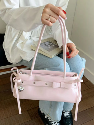 Pink PU leather shoulder bag with bow detail and heart charm