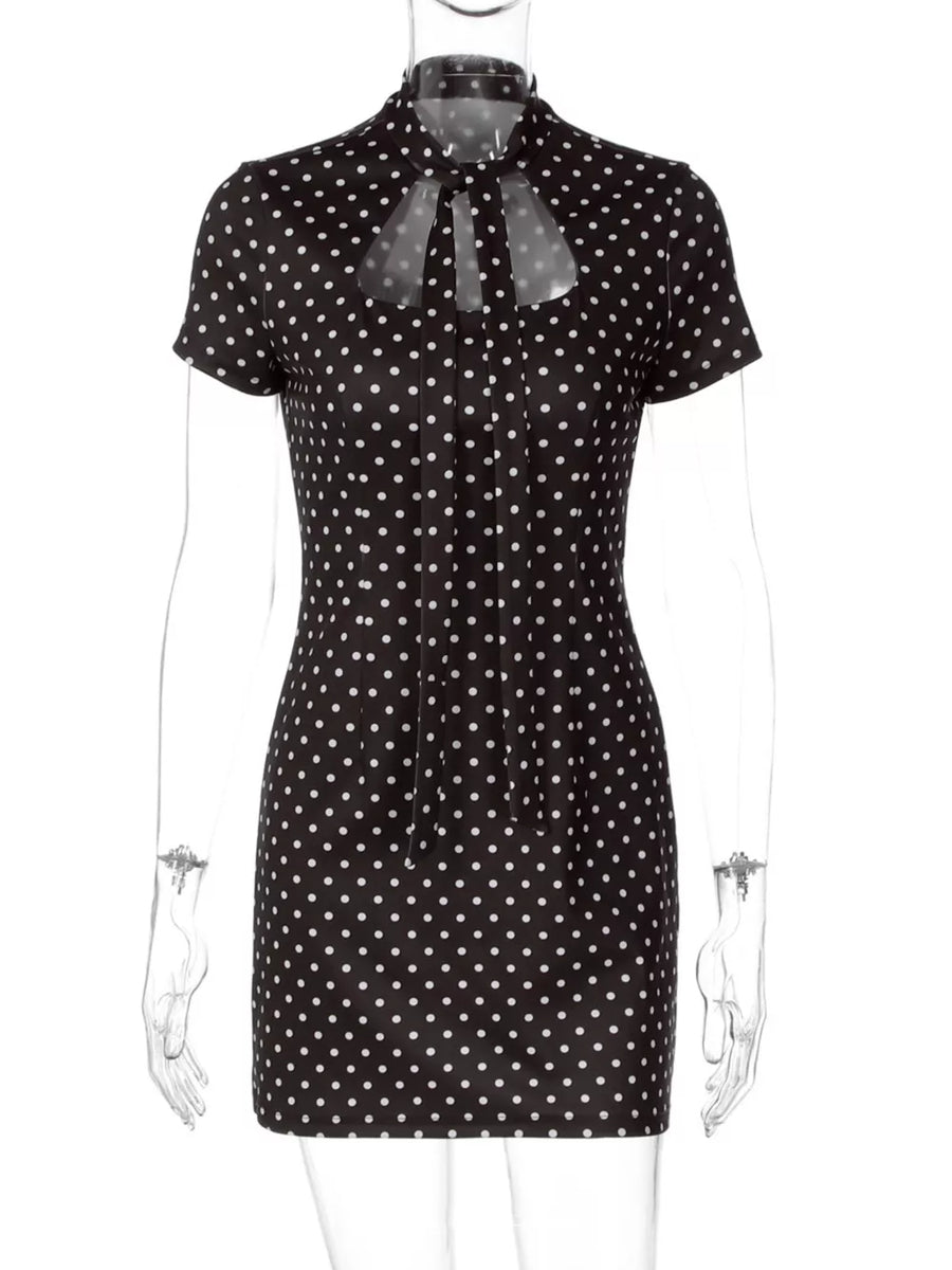 Black polka dot mini dress with short sleeves and a tie-neck cut-out detail.