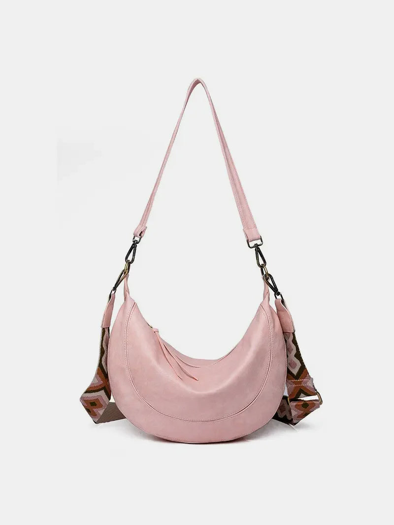Pink leather crescent crossbody bag with geometric strap