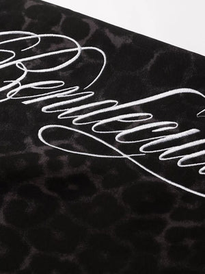 Black leopard print sweatpants with white script embroidery detail.