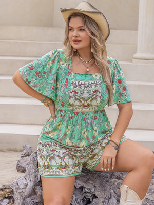 Plus-size green floral romper with square neck, short sleeves, and cinched waist.