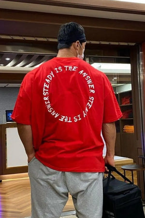 Red oversized t-shirt with white circular text graphic on back