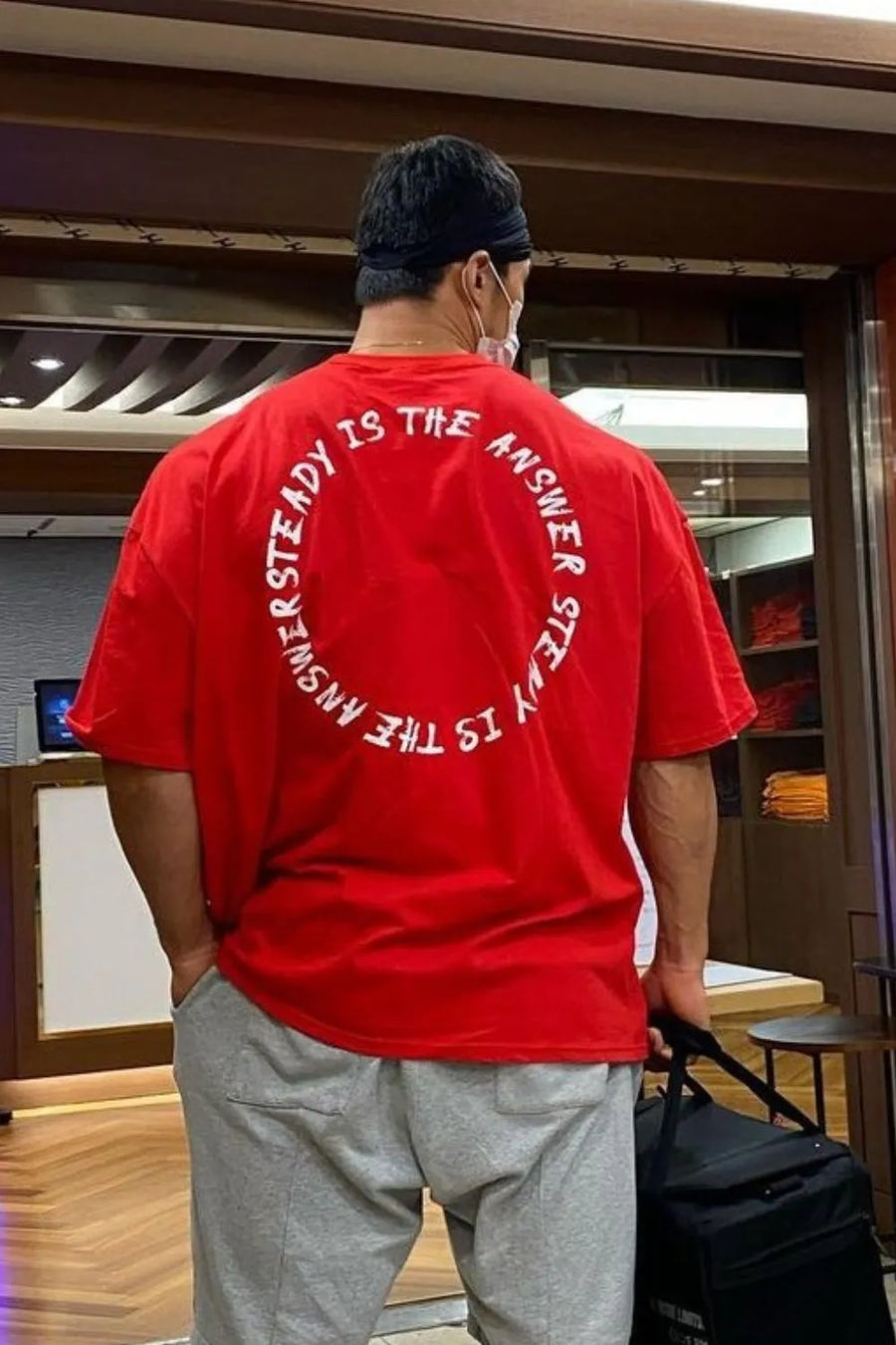 Red oversized t-shirt with white circular text graphic on back