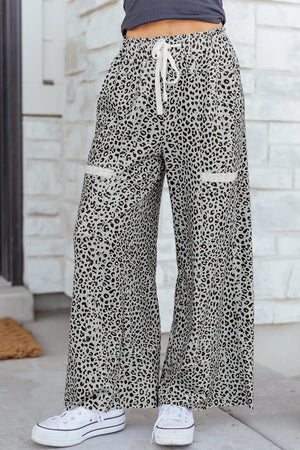 Animal print wide leg pants with drawstring waist and contrast trim pockets.