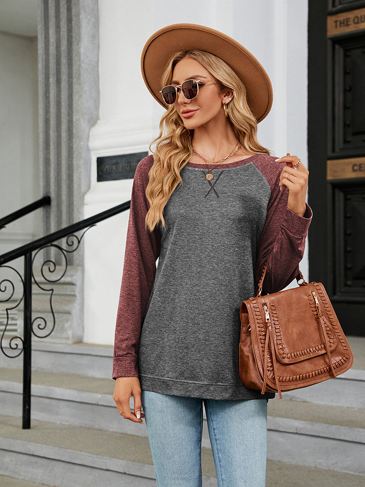 Colorblock raglan crewneck sweatshirt in charcoal and maroon with contrast stitching.