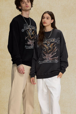 Black oversized sweatshirt with a graphic print and "Miracle" text.