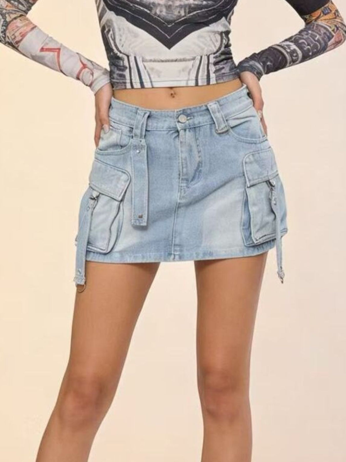 Plus size light wash denim cargo skirt with button closure and utility pockets.