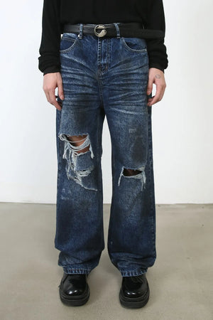 Dark wash denim jeans with distressed rips and a wide leg fit.