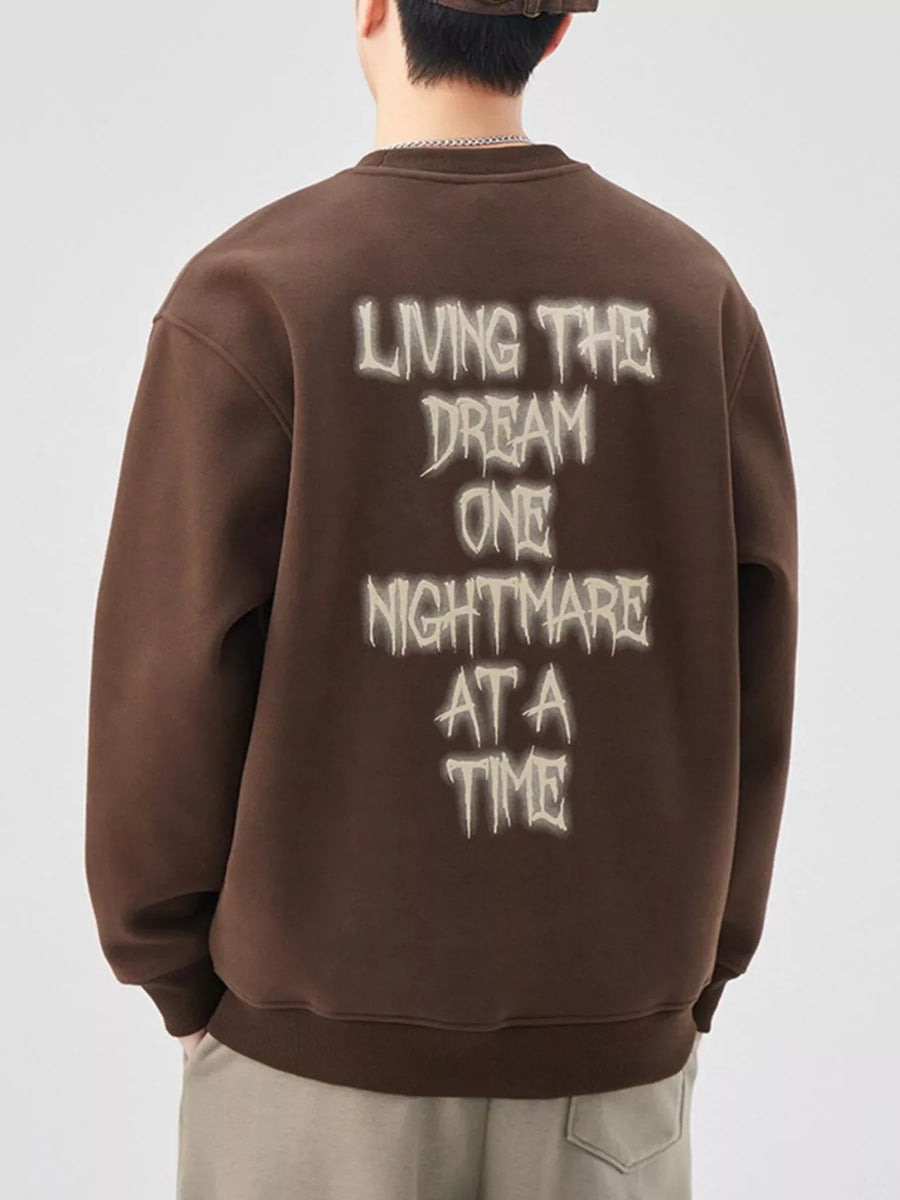 Brown oversized crew-neck sweatshirt with "Living the Dream One Nightmare at a Time" graphic on back