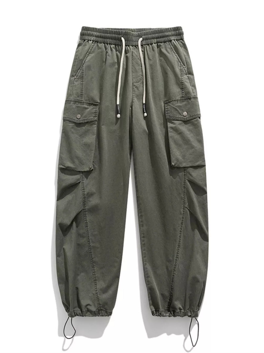 Green cargo pants with drawstring waist, button-down flap pockets, and adjustable cuffs.