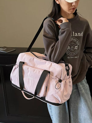 Light purple duffle bag with black straps and pockets, perfect for gym or travel.