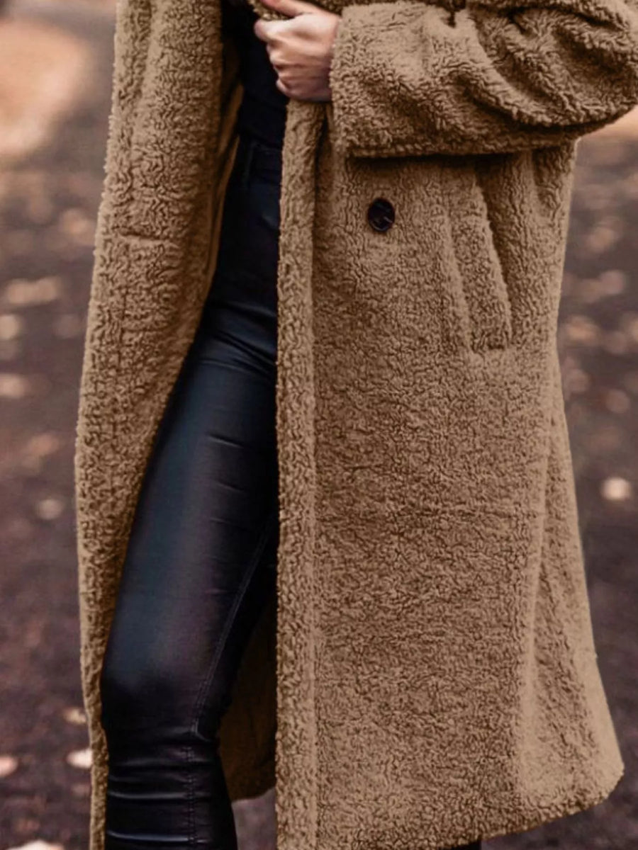 Brown teddy bear longline coat with button detail and pockets, worn over black pants.