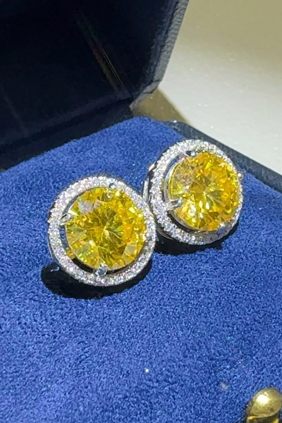 Canary yellow moissanite halo stud earrings with diamond accents.