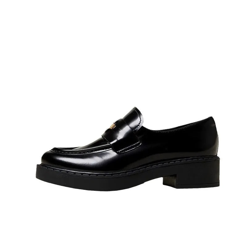 Black patent leather loafers with gold hardware and block heel.