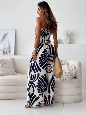 Strapless wide-leg romper in black with tribal print, smocked bodice, and flowy polyester fabric.