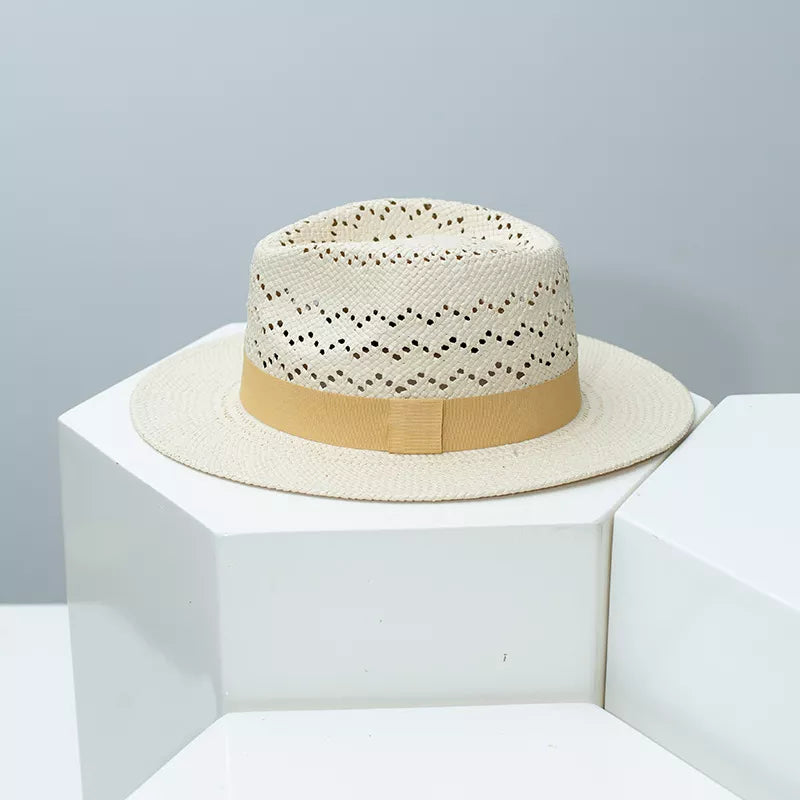 Straw boater hat in natural with ochre ribbon and open weave crown detail.