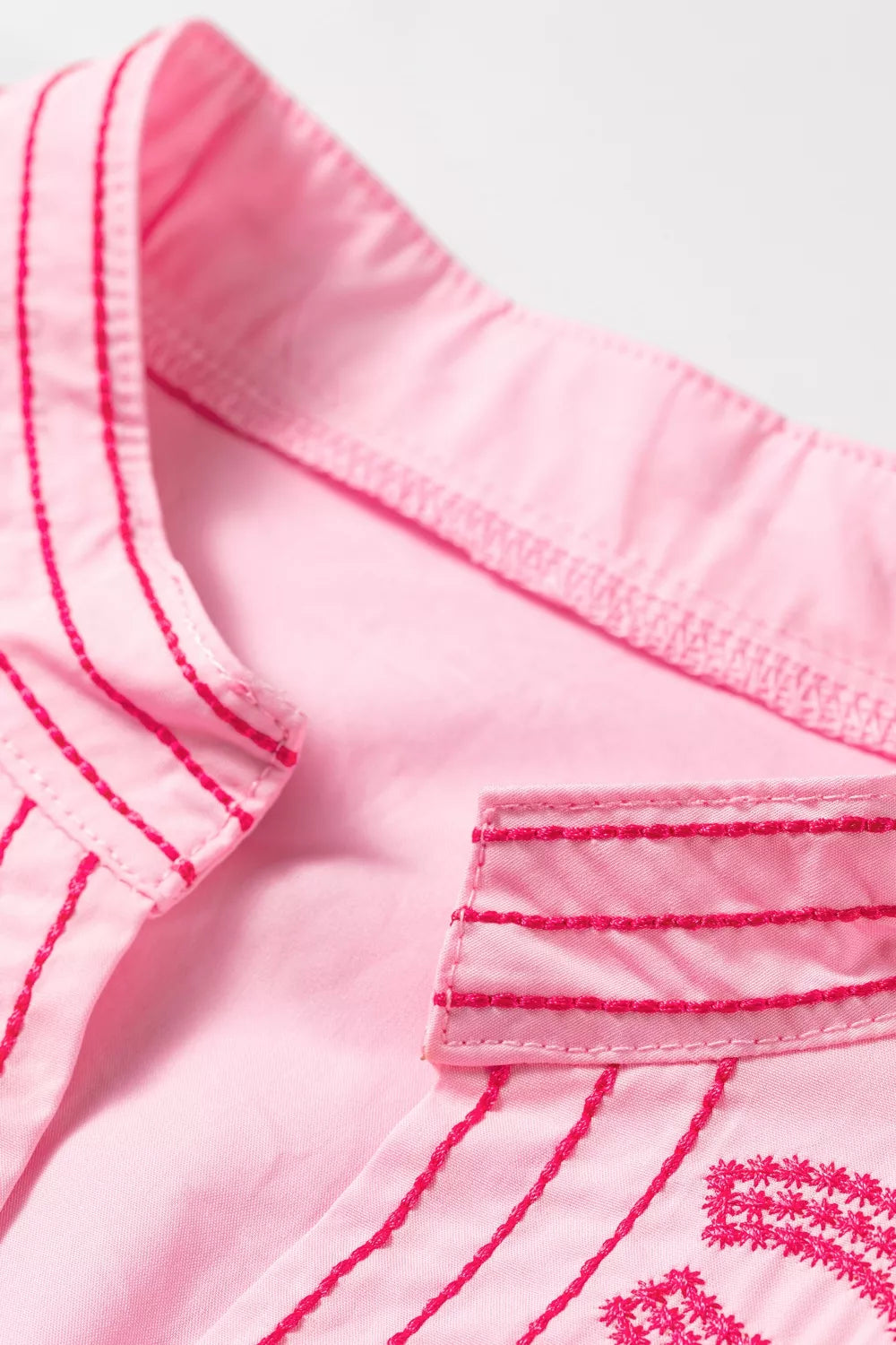 Pink cotton shirt with contrast embroidery detail on collar and placket.