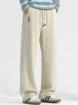 Men's beige casual loose-fit drawstring pants with pockets and side seam detail.